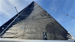 Sail of 2024 Comuzzi Yachts C-32 Sport against a clear blue sky.