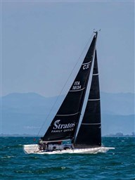 2024 Comuzzi Yachts C-32 Sport sailing on open water with mountains in the background.