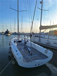 2024 Comuzzi Yachts C-32 Sport sailboat docked in a marina at sunset.
