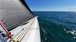 2024 Comuzzi Yachts C-32 Sport sailing on open sea under clear blue sky.
