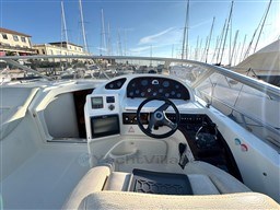 2006 Cranchi Smeraldo 37 yacht cockpit with steering wheel and control panel, docked at marina.