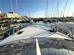 2006 Cranchi Smeraldo 37 yacht docked in a marina, surrounded by sailboats.