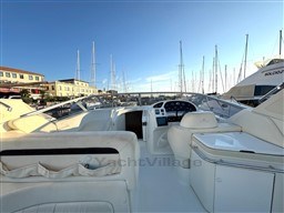 2006 Cranchi Smeraldo 37 yacht interior with white seating, docked at marina under clear sky.