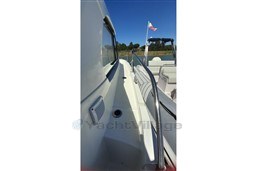 2022 Beneteau Antares 8 Fishing boat deck with railing and flag.