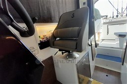 Interior of 2022 Beneteau Antares 8 Fishing boat with captain's chair and storage.