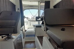 Interior of 2022 Beneteau Antares 8 Fishing boat, featuring seating and helm area.