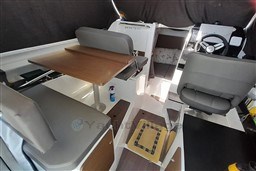 Interior of 2022 Beneteau Antares 8 Fishing boat with seating and steering wheel.