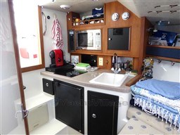 2009 Carolina Classic 28 boat interior with kitchenette, microwave, and sink.