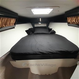 Luxurious cabin interior of 1989 Tecnomar Benetti 50 offshore yacht with black bedding.