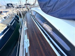 2011 Jeanneau 53 sailboat deck with wooden finish, docked at a marina.