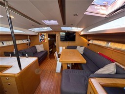 Interior of 2011 Jeanneau 53 yacht with spacious seating, wooden flooring, and modern amenities.