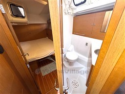 Cabin and bathroom interior of 2011 Jeanneau 53 yacht, featuring wood finishes and compact design.