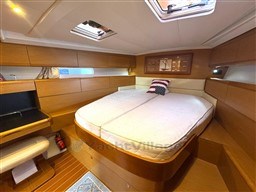 Luxurious cabin interior of a 2011 Jeanneau 53 yacht with a comfortable bed and wooden furnishings.