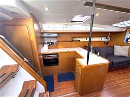 Interior of 2011 Jeanneau 53 yacht with modern kitchen and cozy seating area.