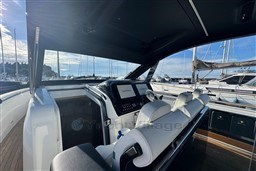 2023 Invictus TT 420 yacht interior with modern helm and marina view.