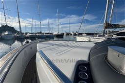 2023 Invictus TT 420 yacht docked in a marina with sailboats.