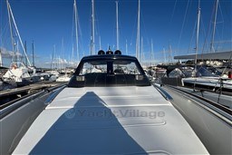 2023 Invictus TT 420 yacht docked at marina under clear blue sky.