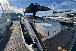 2023 Invictus TT 420 yacht docked at marina under clear blue sky.