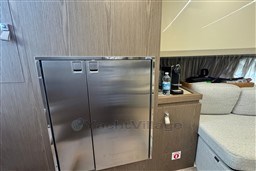 Interior of 2023 Invictus TT 420 yacht with stainless steel cabinet and cozy seating area.