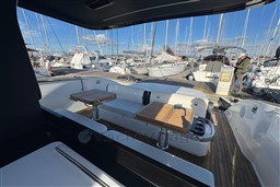 2023 Invictus TT 420 yacht interior with wooden tables, docked at marina.