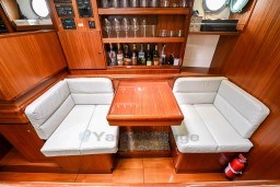 Luxurious 1978 Custom Stain 70 Gulet interior with wooden dining area and bar setup.
