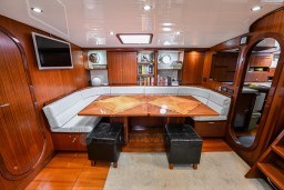 Luxurious interior of 1978 Stain 70 Gulet yacht with wood paneling and cozy seating area.
