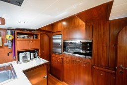 Luxurious wooden kitchen interior on 1978 Stain 70 Gulet yacht, featuring modern appliances.