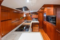 Luxurious wooden kitchen interior on 1978 Stain 70 Gulet yacht, featuring modern appliances.