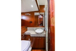 Luxurious wooden bathroom interior on 1978 Stain 70 Gulet yacht, featuring modern sink and mirror.