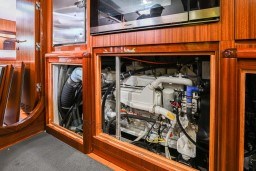 Engine room of 1978 Stain 70 Gulet yacht with visible machinery and wooden paneling.