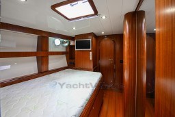 Luxurious wooden cabin interior of 1978 Stain 70 Gulet yacht with bed and portholes.