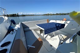 2024 Beneteau Flyer 9 SUNdeck boat interior with seating and table on a sunny day.