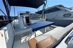 2024 Beneteau Flyer 9 SUNdeck boat interior with seating and table, docked beside another vessel.