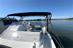 2024 Beneteau Flyer 9 SUNdeck boat on calm water under clear blue sky.