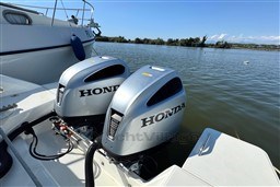 2024 Beneteau Flyer 9 SUNdeck with dual Honda outboard engines on a calm lake.