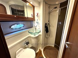 Luxurious bathroom in 2006 Sunseeker Portofino 53 yacht with glass sink and shower.
