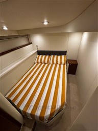 Interior cabin of 2006 Sunseeker Portofino 53 with striped bedding and modern lighting.