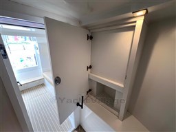 2024 VanDutch 32 Diesel interior with open storage cabinet and modern design.