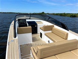 2024 VanDutch 32 Diesel boat with tan seating on a calm lake.