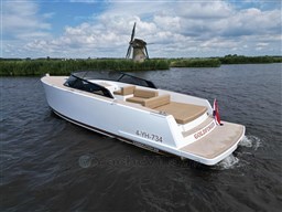 2024 VanDutch 32 Diesel yacht cruising on a scenic waterway with a windmill backdrop.