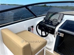 2024 VanDutch 32 Diesel boat cockpit with modern controls and tan seating, overlooking serene water.