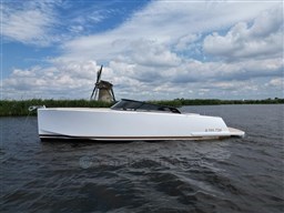 2024 VanDutch 32 Diesel boat on a scenic waterway with a windmill in the background.