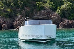 2017 VanDutch 40 yacht in clear turquoise water near rocky shoreline.