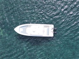 Aerial view of 2005 Boston Whaler 320 Outrage boat on clear blue water.