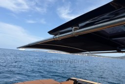 2022 Pardo Yachts P43 with sunshade, cruising on a clear blue sea.