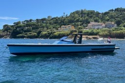 A 2004 Wally 45 yacht on serene blue waters with lush green hills in the background.
