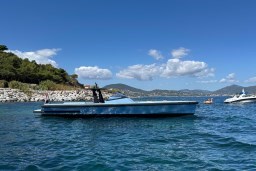 2004 Wally 45 yacht on blue water, scenic coastal backdrop, clear sky.