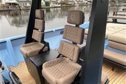 Luxurious seating on a 2004 Wally 45 yacht with quilted upholstery and waterfront view.