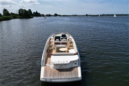 2023 Invictus GT 280 luxury boat on a serene lake with scenic surroundings.