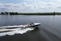 2023 Invictus GT 280 cruising on a serene river with lush green landscape.